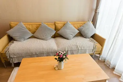 a living room with a couch with pillows and a table at Lux Condo 2BR - 5 mins walk to BTS Phrom Phong in Bangkok