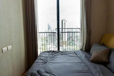 a bedroom with a bed and a large window at Lux Condo 2BR - 5 mins walk to BTS Phrom Phong in Bangkok