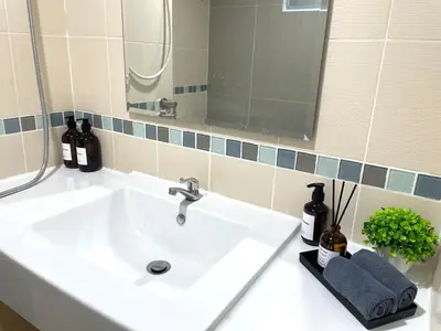 a bathroom with a white sink and a mirror at Cozy style 2BR 2B near street food in city in Bangkok