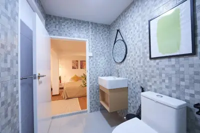 a bathroom with a toilet and a sink and a bedroom at Arta House in Bangkok