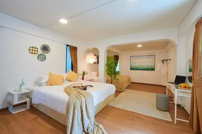 a bedroom with a white bed and a desk at Arta House in Bangkok