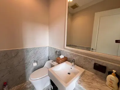 a bathroom with a sink and a toilet and a mirror at Luxury private swimming pool house for 10pax in Bangkok