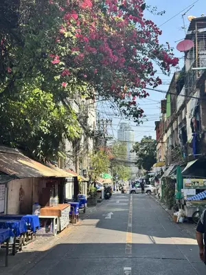 a city street with a tree with pink flowers at King Room + Fast Wi-Fi • Ekkamai BTS Nearby in Khlong Toei