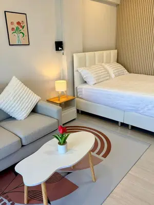 a living room with two beds and a coffee table at Cozy Studio near Train Night market & BKK Airport in Bangna