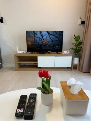 a living room with a tv and two remote controls at Cozy Studio near Train Night market & BKK Airport in Bangna