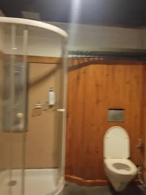 a bathroom with a toilet and a glass door at Spacious City-View Apartment with Modern Amenities in Krung Thep in Amphoe Phra Khanong