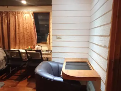 a living room with a table and a leather couch at Spacious City-View Apartment with Modern Amenities in Krung Thep in Amphoe Phra Khanong