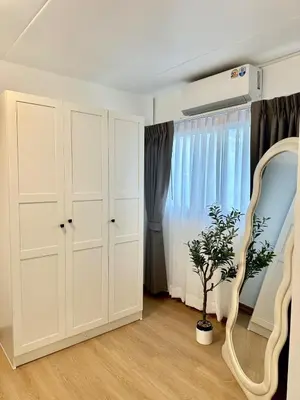 a room with a white cabinet and a plant at Jumboboom in Ban Bang Phang