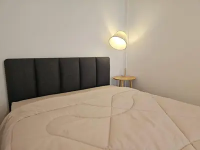 a bedroom with a large bed with a lamp on it at Jumboboom in Ban Bang Phang