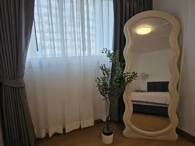 a mirror in a room with a bed and a window at Jumboboom in Ban Bang Phang