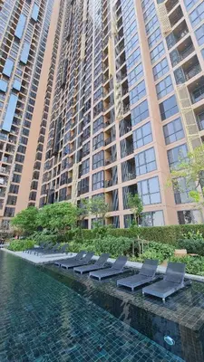 a row of lounge chairs in front of a large building at Perfect WFH 5 mins THONG LOR ultra luxury in Bangkok