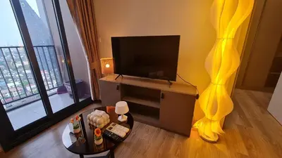 a living room with a flat screen tv and a table at Perfect WFH 5 mins THONG LOR ultra luxury in Bangkok