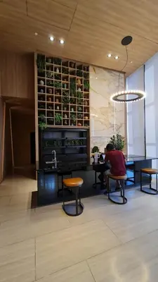 a lobby with chairs and a kitchen with plants on the wall at Perfect WFH 5 mins THONG LOR ultra luxury in Bangkok