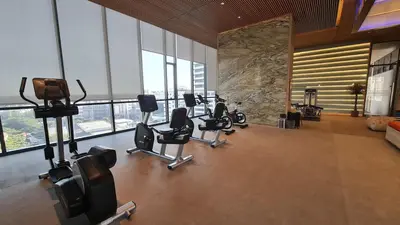 a gym with a row of exercise equipment in a room at Perfect WFH 5 mins THONG LOR ultra luxury in Bangkok