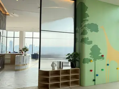 a lobby with a green wall with a tree mural at Bangkok Rama9 Cassia & Siamese in Bangkok