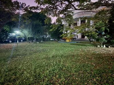 a park in front of a building at night at Worsakornrit Homestay in Bangkok