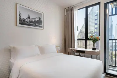 a white bedroom with a large bed and a window at Hampton Residence Phayathai in Sathani Sam Sen