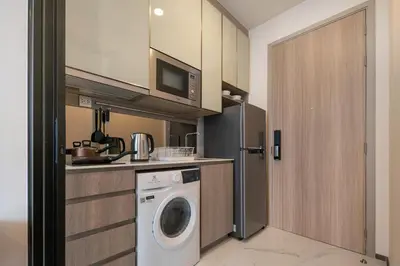 a kitchen with a washer and dryer in a room at Hampton Residence Phayathai in Sathani Sam Sen