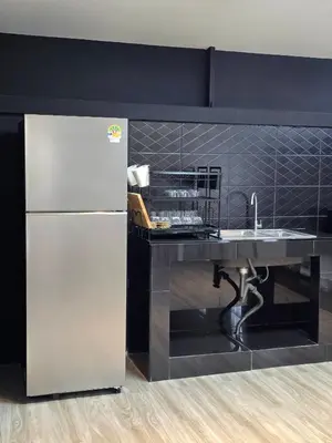 a kitchen with a white refrigerator and a counter at Baan White House in Ban Baen Phichit