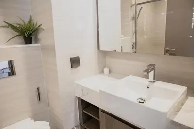 a bathroom with a white sink and a mirror at Hampton Residence Thonglor in Khlong Toei