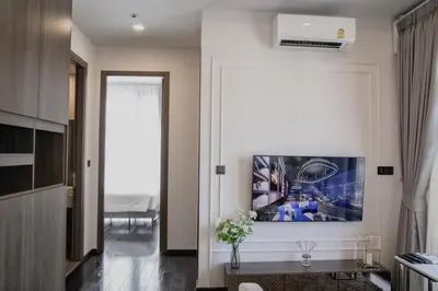 a living room with a large painting on the wall at Hampton Residence Thonglor in Khlong Toei
