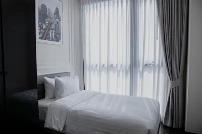 a bedroom with a white bed and a window at Hampton Residence Thonglor in Khlong Toei