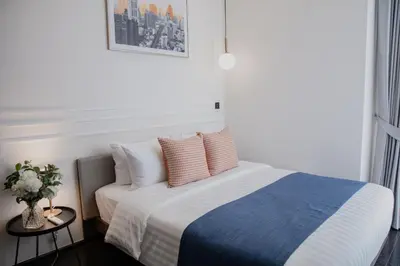 a bedroom with a blue and white bed with pillows at Hampton Residence Thonglor in Khlong Toei