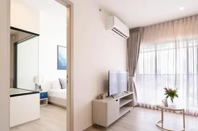 a living room with a tv and a window at The Hampton Suites Bangna in Bangna