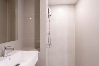 a bathroom with a shower with a sink and a shower at The Hampton Suites Bangna in Bangna
