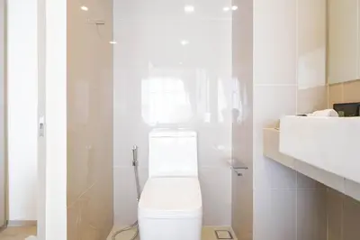 a white bathroom with a toilet and a sink at The Hampton Suites Bangna in Bangna