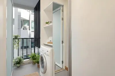 a laundry room with a washing machine next to a window at Designer Home BTS bangkok centre Pool Gym