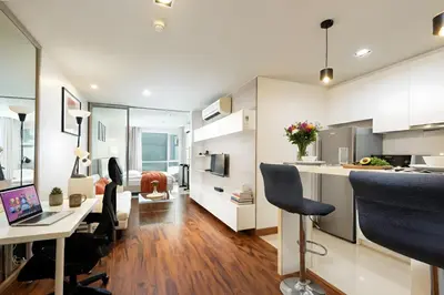 an open kitchen and living room with a desk and chairs at Designer Home BTS bangkok centre Pool Gym