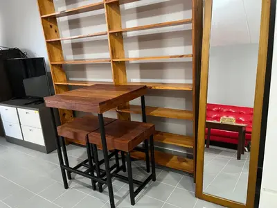 a book shelf with a wooden table and stool at Impact Arena C5 by Jintana in Thung Si Kan