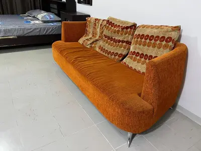 a brown couch with two pillows on it in a room at Impact Arena C5 by Jintana in Thung Si Kan