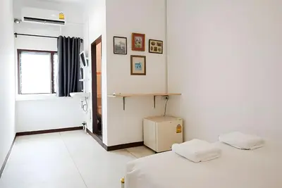 a white room with a bed and a window at GO INN Asiatique - Riverfront Bang Kho Laem