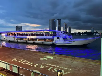 a cruise ship in the water with a city in the background at GO INN Asiatique - Riverfront Bang Kho Laem