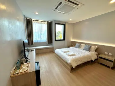 a bedroom with a bed and a desk in it at Whiteinn - ไวท์อินน์ in Nonthaburi
