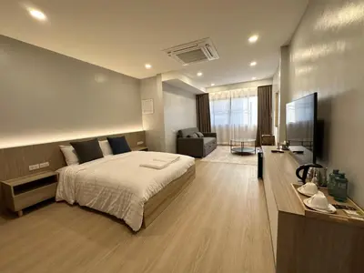 a bedroom with a large bed and a television at Whiteinn - ไวท์อินน์ in Nonthaburi