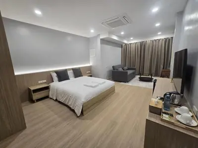 a hotel room with a bed and a television at Whiteinn - ไวท์อินน์ in Nonthaburi