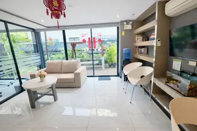 a living room with a couch and a table and chairs at Bright & Green apartment on BTS Thonglor in Bangkok