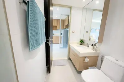 a bathroom with a toilet and a sink and a mirror at Bright & Green apartment on BTS Thonglor in Bangkok