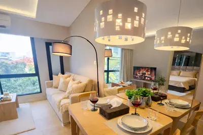 a living room with a table with glasses of wine at Bright & Green apartment on BTS Thonglor in Bangkok