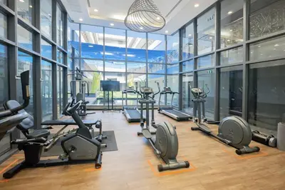a gym with a bunch of treadmills and ellipticals at Bright & Green apartment on BTS Thonglor in Bangkok