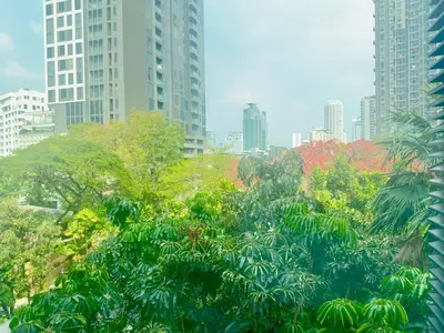 a city skyline with tall buildings and trees at Bright & Green apartment on BTS Thonglor in Bangkok