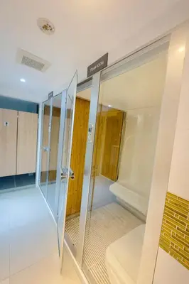 a glass elevator in a room with a door at Bright & Green apartment on BTS Thonglor in Bangkok
