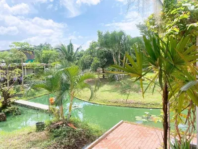a view from the garden of a resort with a pond at Chan Klong No8 Homestay - บ้านชานคลองหมายเลข8 in Sathani Wat Sing