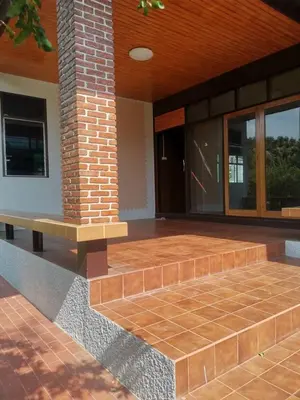 a porch of a house with a brick pillar and a bench at Chan Klong No8 Homestay - บ้านชานคลองหมายเลข8 in Sathani Wat Sing