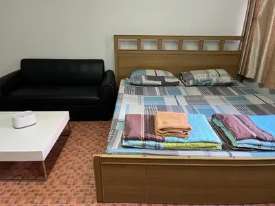 a bed and a couch in a room at Impact Arena C9 by Jintana in Thung Si Kan