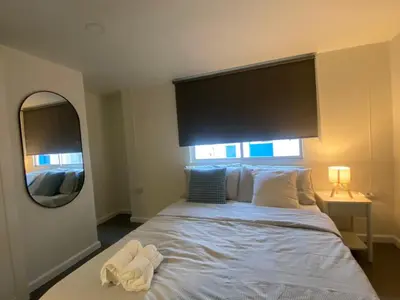 a bedroom with a bed with a large headboard and a mirror at Sawasdee Bangkok Condo Modern 2BR BTS Srinakarin38 connect Sukhumvit Route 20mins Aiport and 15mins Sukhumvit Line in Bangna