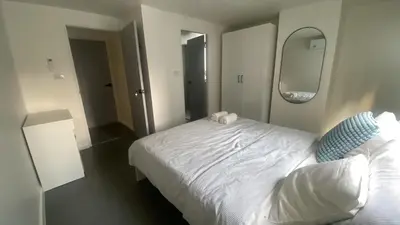 a bedroom with a white bed and a mirror at Sawasdee Bangkok Condo Modern 2BR BTS Srinakarin38 connect Sukhumvit Route 20mins Aiport and 15mins Sukhumvit Line in Bangna